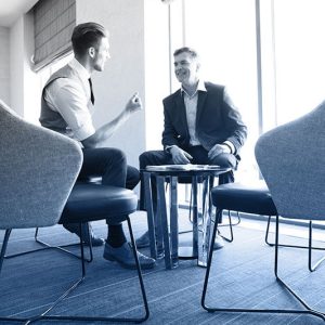 Zwei Männer sitzend im Gespräch - Mitarbeitergespräch
